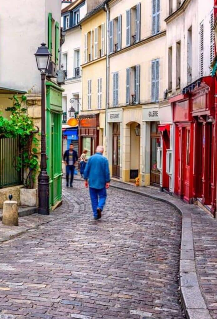 A picturesque cobbled street in the Village de Charonne, 20th arrondissement of Paris, featuring colorful storefronts, historic buildings, and a peaceful village-like atmosphere