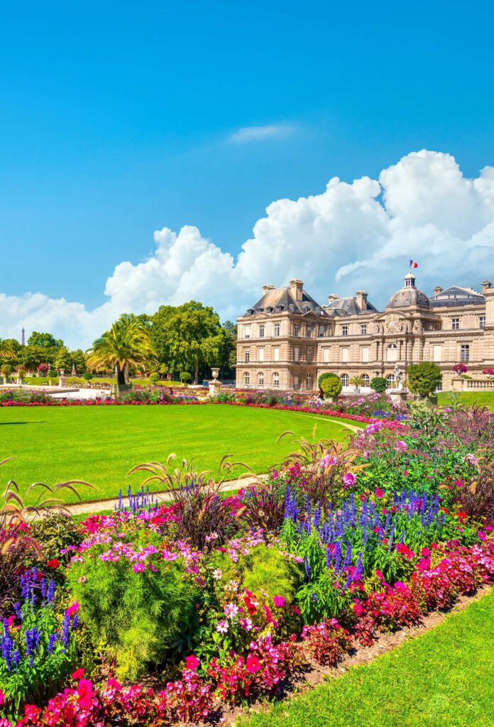 The Luxembourg Gardens in Paris, featuring vibrant flower beds, lush green lawns, and the historic Luxembourg Palace. A tranquil oasis in the 6th arrondissement, popular with locals, tourists, and expatriates