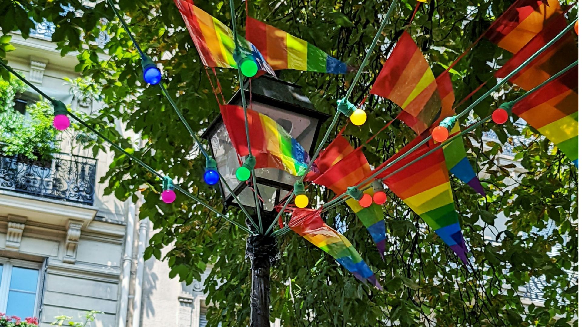 Colorful rainbow flags and festive lights captured during the Paris Gay Pride 2025 celebrations.