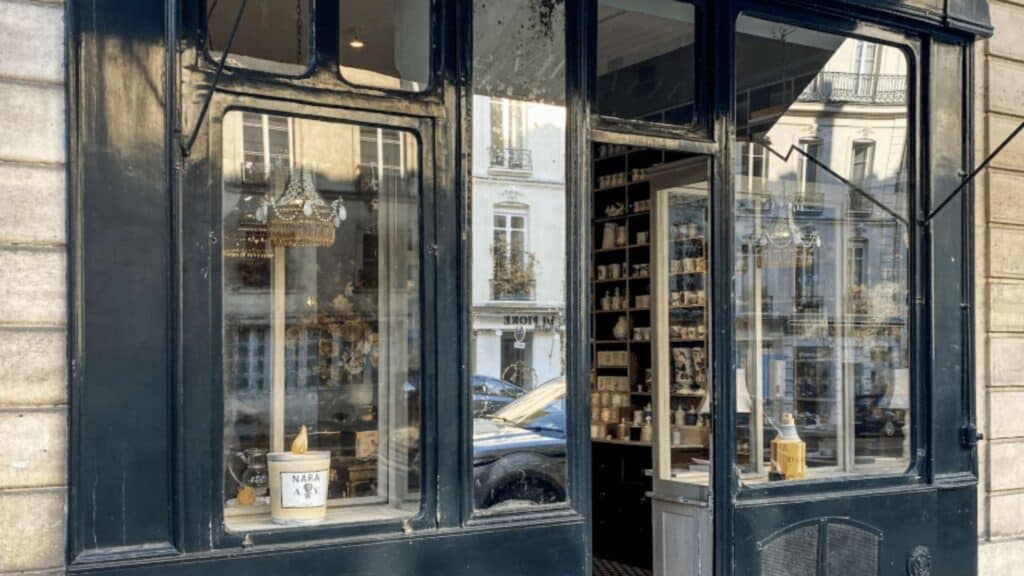 Charming Parisian shopfront in the Marais with vintage decor and inviting open door.