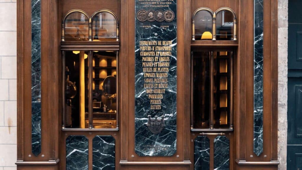 Renovated Parisian restaurant facade with dark marble accents and wooden details in a classic Parisian style.