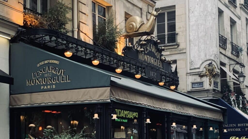 L'Escargot Montorgueil restaurant facade with decorative snail sculpture, Paris street scene.