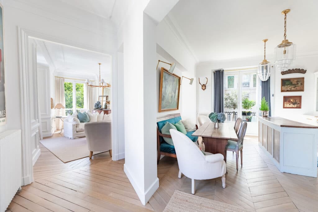 Chic Parisian apartment with parquet floors, open dining area, and bright living room in classic Haussmann style.