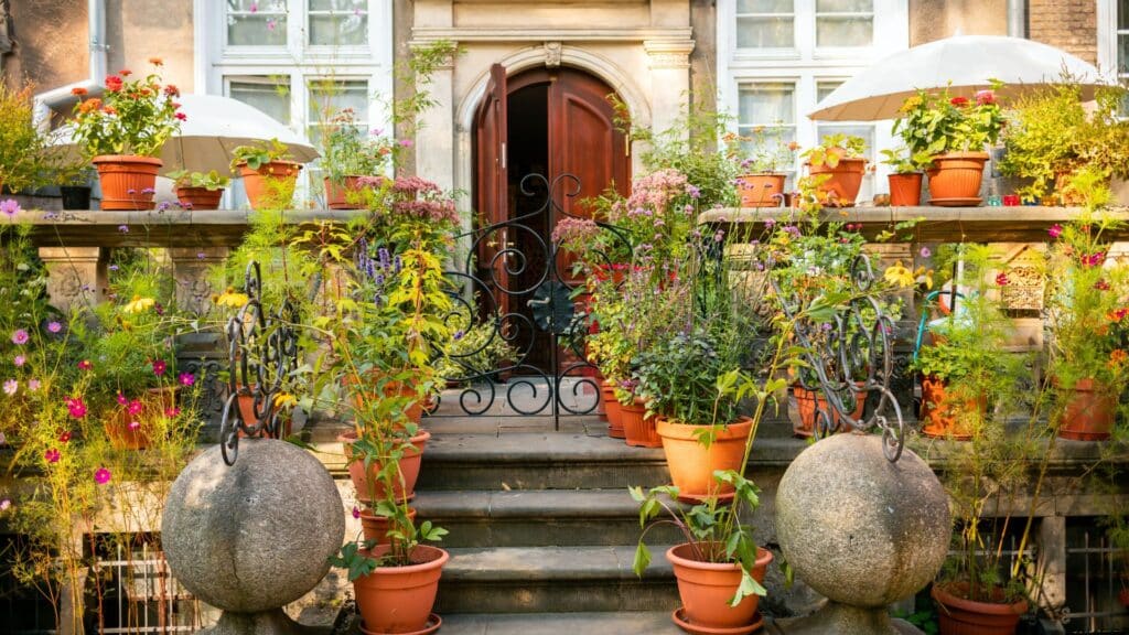 Charming Parisian terrace with colorful potted plants and ornate iron railings.